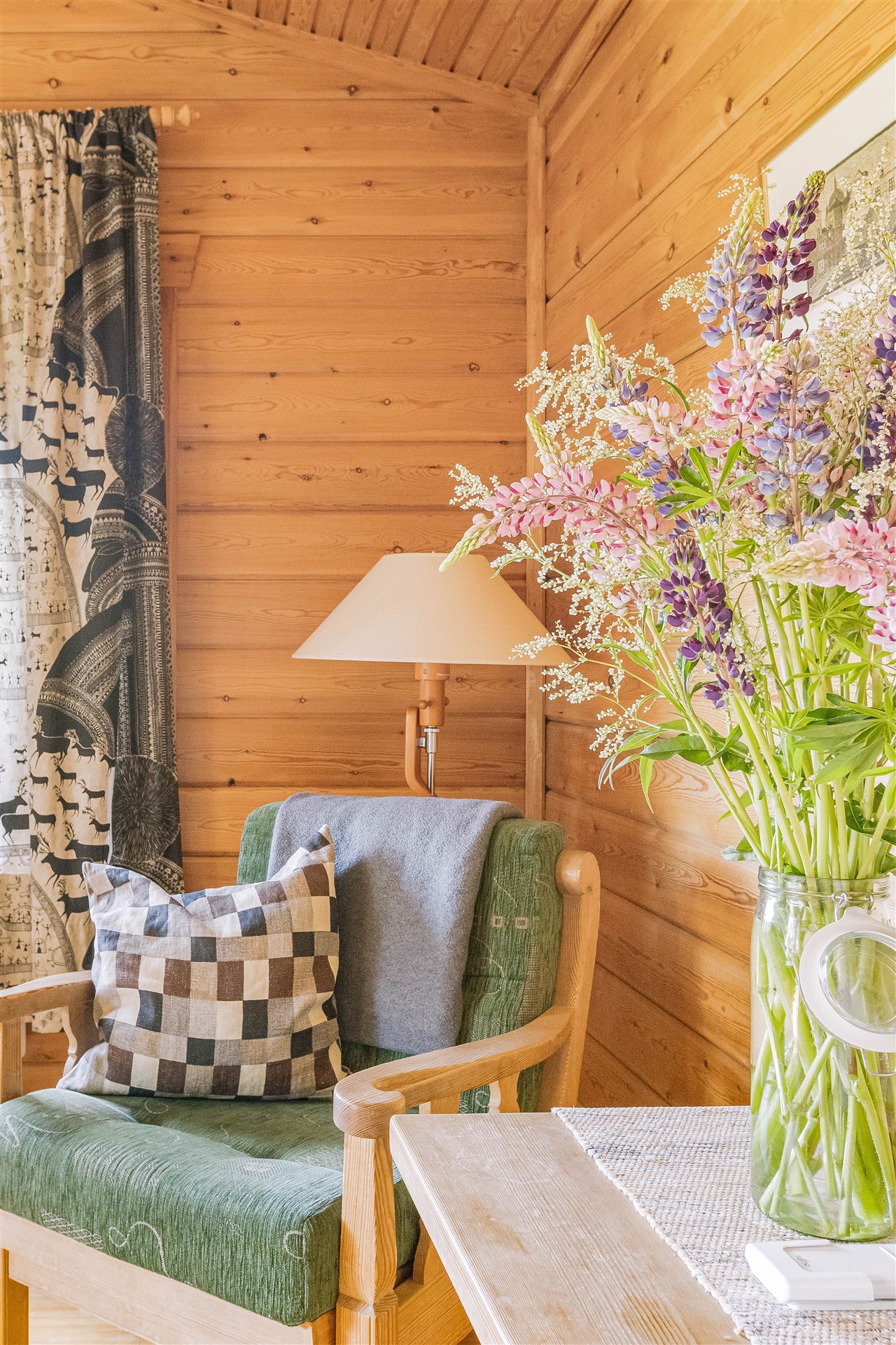 Detalj i allrum med fåtölj och blommor